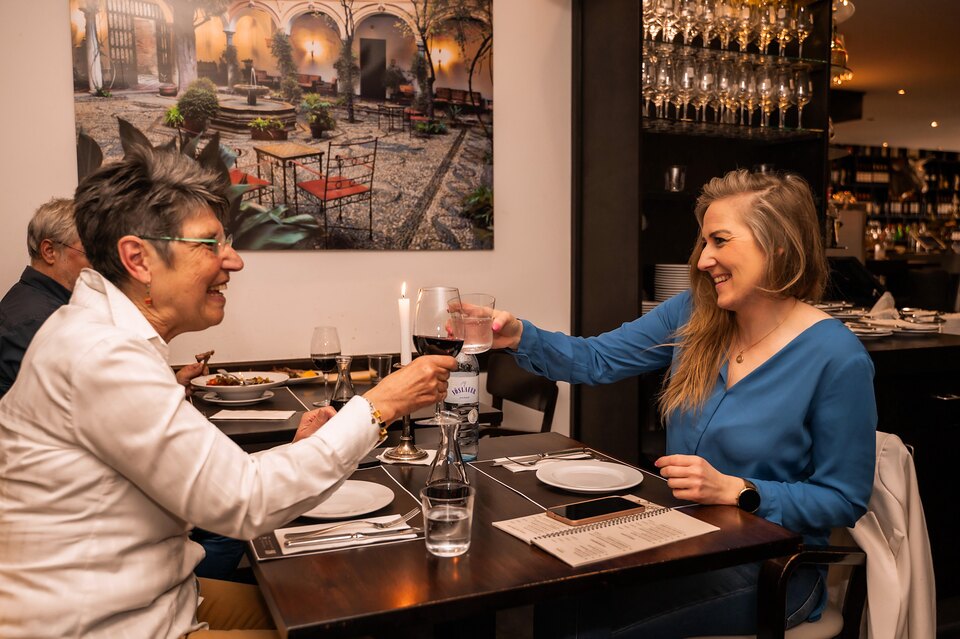 Zwei Gäste stoßen im Pelayo mit Wein an